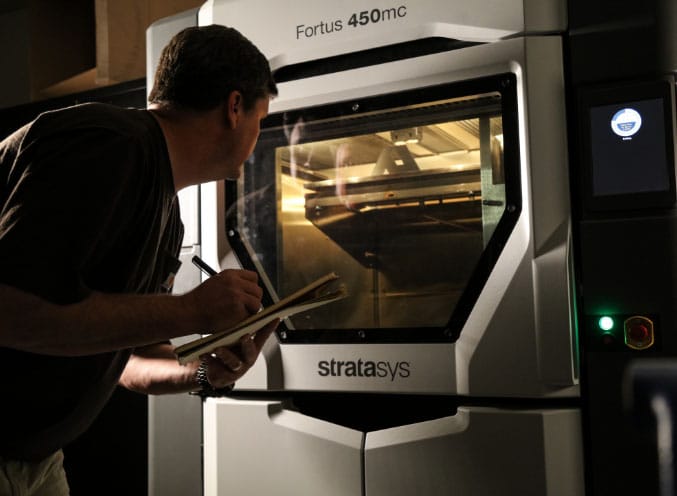 man looking into a 3d printer